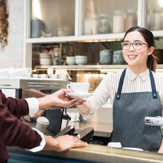 Barista handing over coffee to a customer to promote hospitality insurance by Evalee Insurance Brokers